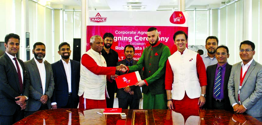 Adam Tamiji Haque, Managing Director of A T Haque Limited and Mahtab Uddin Ahmed, CEO of Robi, exchanging an agreement signing documents at Haque Group's office in the city recently. Under the deal, AT Haque Limited will enjoy Robi's corporate solutions