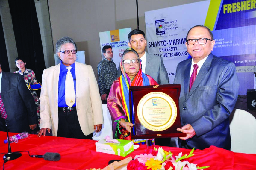 Founder of Shanto -Mariam Foundation and eminent freedom fighter Md Enamul Kabir Shanto handing over a citation crest to Begum Rashida Hamid, wife of President Md Abdul Hamid at freshers' reception of Shanto -Mariam University of Creative Technology