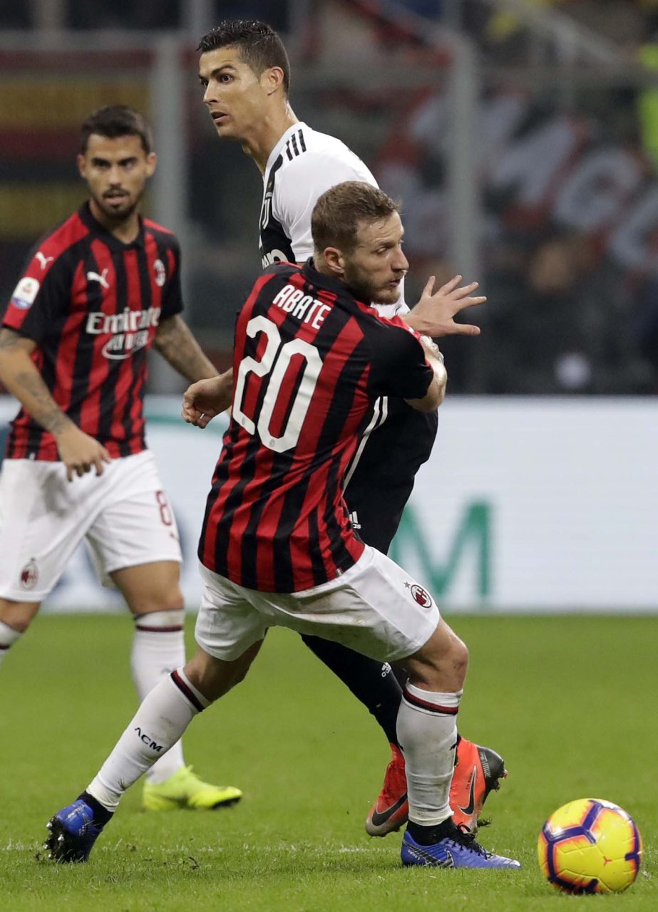 Juventus' Cristiano Ronaldo (top) and AC Milan's Ignazio Abate fight for the ball during a Serie A soccer match between AC Milan and Juventus at Milan's San Siro stadium on Sunday.