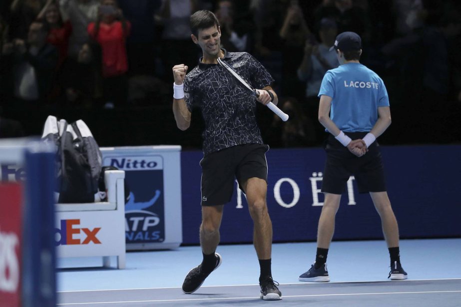 Novak Djokovic of Serbia celebrates winning match point against John Isner of the United States in their ATP World Tour Finals tennis match at the O2 Arena in London on Monday.