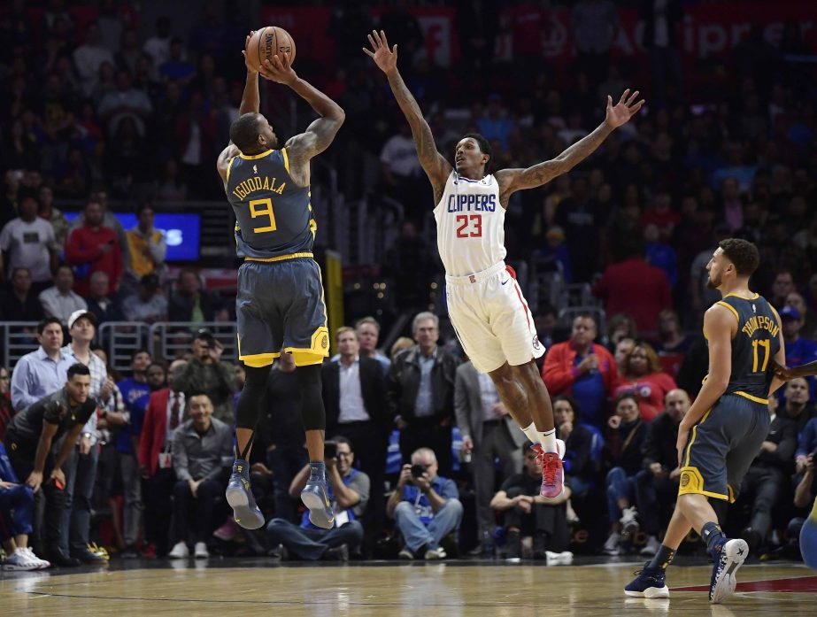 Golden State Warriors guard Andre Iguodala (left) takes a last-second shot as Los Angeles Clippers guard Lou Williams (center) defends and guard Klay Thompson watches during overtime of an NBA basketball game in Los Angeles on Monday. The Clippers won 121