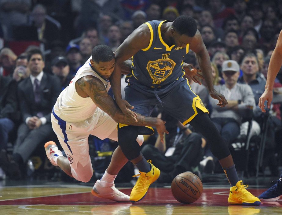 Los Angeles Clippers guard Sindarius Thornwell (left) and Golden State Warriors forward Draymond Green scramble for a loose ball during the first half of an NBA basketball game in Los Angeles on Monday.