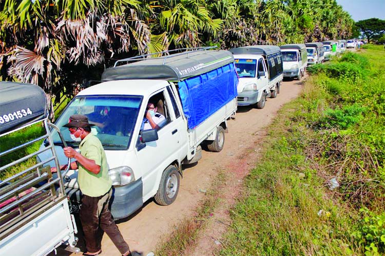 Vehicles line up to transport Rohingya Muslims detained by Myanmar immigration authorities after arriving by boat at Thande village outside Yangon in Myanmar on Friday.
