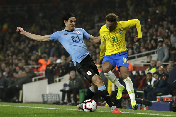 Uruguay's Edinson Cavani (left) stops Brazil's Neymar during the international friendly soccer match between Brazil and Uruguay at the Emirates Stadium, London on Friday.