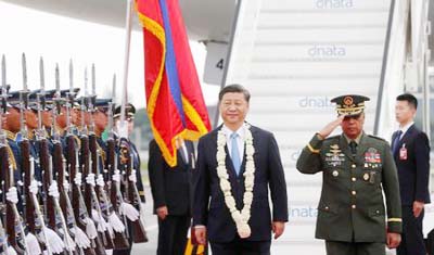China's President Xi Jinping walks past honour guards upon his arrival at Ninoy Aquino International airport during a state visit in Manila on Tuesday.