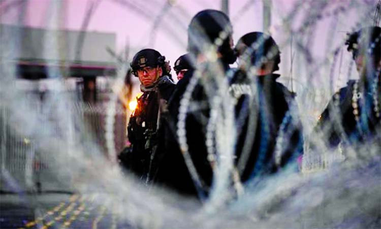 U.S. Customs and Border Protection (CBP) Special Response Team (SRT) officers are seen through concertina wire at the San Ysidro Port of Entry after the land border crossing was temporarily closed to traffic in Tijuana, Mexico.