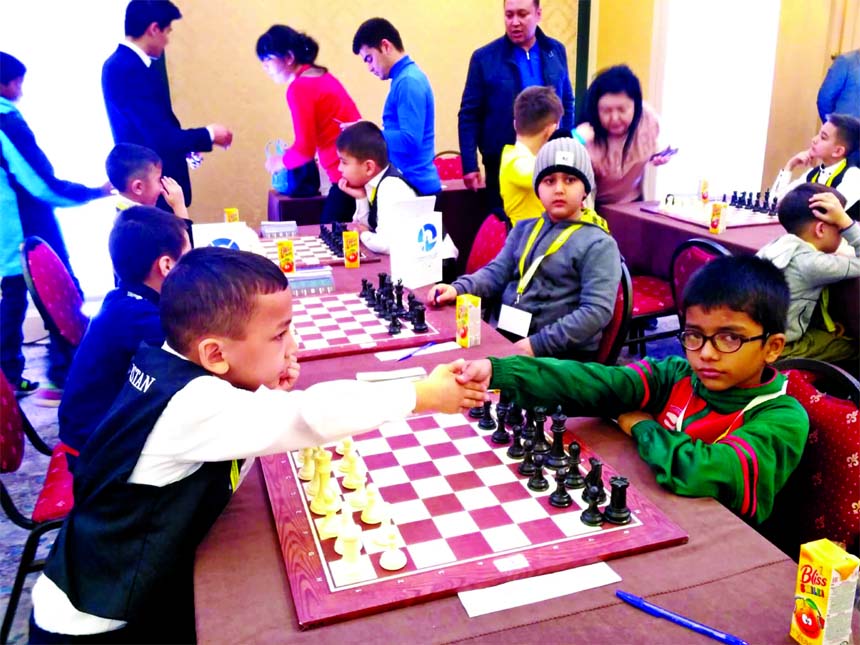 CM Manon Reja Neer (right) of Bangladesh shaking hands with Komilov Jahangir of Uzbekistan during ninth round game of Open Under-8 Group of Western Asia Youth & Junior Chess Championship at Tashkent in Uzbekistan on Thursday. Manon Reja Neer became unbeat