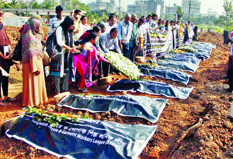 Families and members of various workers' organisations placing wreaths at the graves of victims marking the Tazreen Garments Tragedy Day at the Jurain graveyard on Saturday.