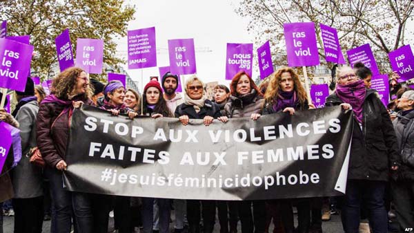 French actress Muriel Robin, center, marches with participants holding a banner that reads "Stop violence towards women" as they take part in a rally in Paris on Saturday.