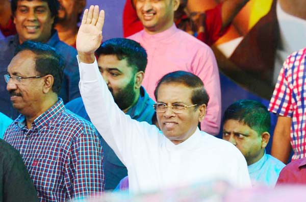 Sri Lanka's President Maithripala Sirisena waves to supporters at a rally in Colombo.