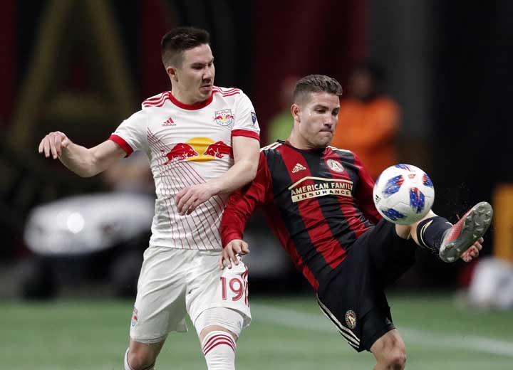 Atlanta United defender Greg Garza (right) controls the ball as New York Red Bulls midfielder Alex Muyl (19) defends In the second half of an MLS soccer playoff game in Atlanta on Sunday.