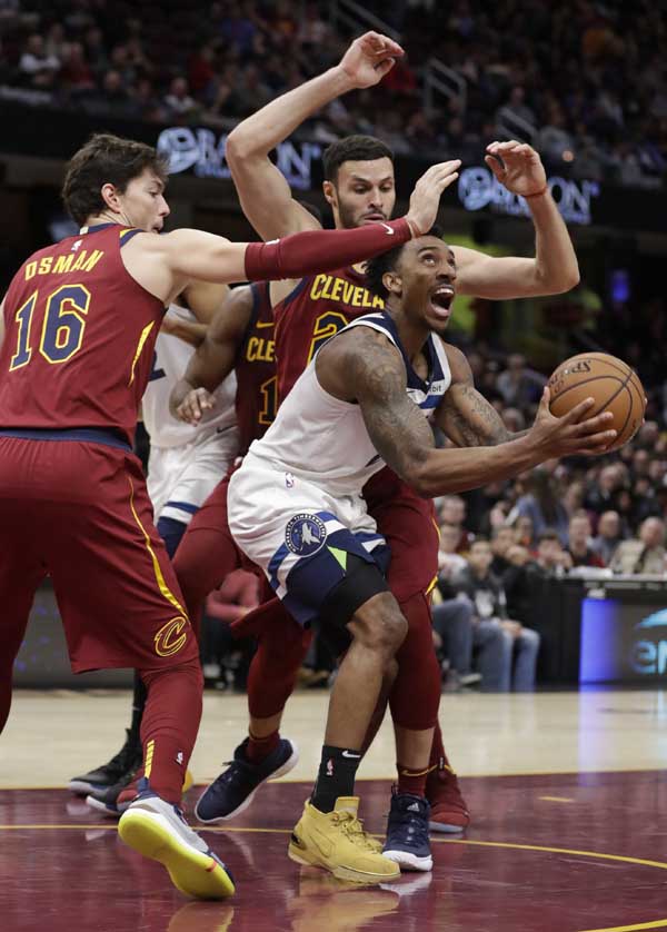 Minnesota Timberwolves' Jeff Teague (center) drives to the basket between Cleveland Cavaliers' Cedi Osman (left) from Turkey, and Larry Nance Jr. in the second half of an NBA basketball game in Cleveland on Monday.