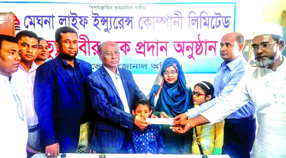 Nizam Uddin Ahmed, Chairman of Meghna Life Insurance Company Limited, handing over a cheque for Tk. 14,00,000- to Rahima Begum, wife of policyholder late Nazrul Islam at its Bhola Zonal office recently. Other senior officials of the company were also pre