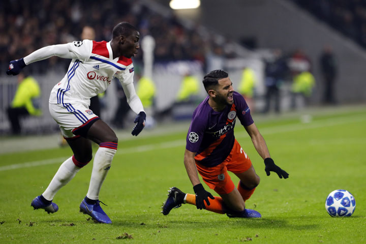 Manchester City midfielder Riyad Mahrez, falls down after being tackled by Lyon defender Ferland Mendy during the Champions League Group F second leg soccer match between Lyon and Manchester City, in Decines, near Lyon, central France on Tuesday.