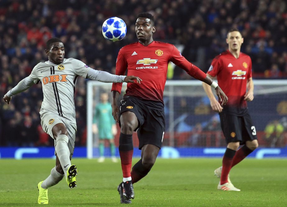 ManU midfielder Paul Pogba vies for the ball with Young Boys' Roger Assale (left) during the Champions League group H soccer match between Manchester United and Young Boys at Old Trafford Stadium in Manchester, England on Tuesday.