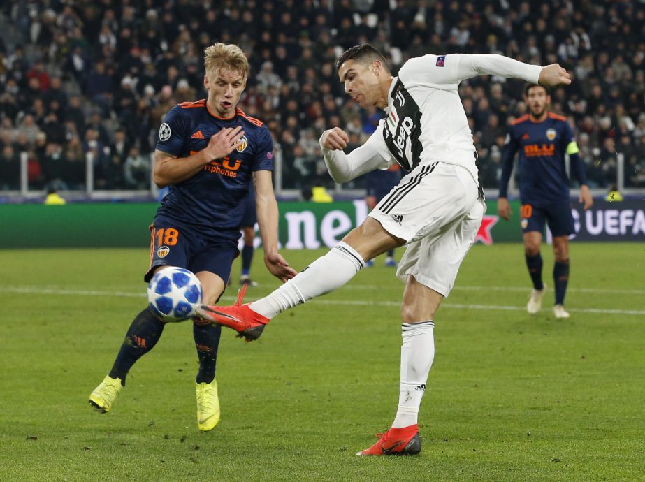 Juventus forward Cristiano Ronaldo (right) challenges for the ball with Valencia midfielder Daniel Wass during the Champions League group H soccer match between Juventus and Valencia at the Allianz stadium in Turin, Italy on Tuesday.