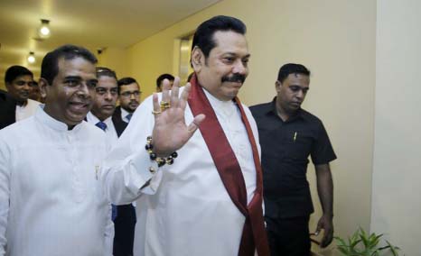 Sri Lanka's disputed Prime Minister Mahinda Rajapaksa, gestures as he arrives for a meeting with his supporting law makers at the parliamentary complex in Colombo, Sri Lanka on Thursday