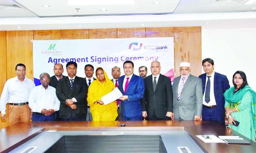 Dr. Hosne-Ara Begum, Chairman of Momo Inn Hotel & Resort Ltd and Executive Director of TMSS and Muhammad H Kafi, Head of Cards of NCC Bank Ltd, sign an agreement at the Bank's head office recently. Mosleh Uddin Ahmed, Managing Director of the Bank was al