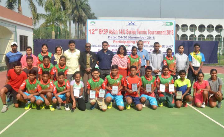 Tennis players of BKSP, the winners of the 12th BKSP Asian Under-14 Series Tennis Tournament with the chief guest Director (Training) of BKSP Dr Mohiuddin Ahmed pose for a photo session at the tennis court in BKSP, Savar on Friday. Tennis players from Ba
