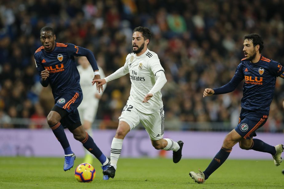Real Madrid's Isco (centre) runs with the ball during a Spanish La Liga soccer match between Real Madrid and Valencia at the Santiago Bernabeu stadium in Madrid, Spain on Saturday.