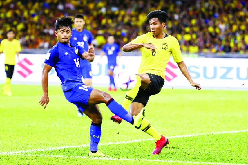 Malaysia's Muhammad Syazwan and Andik Mohd Ishak (right) battle for the ball with Thailand's Sasalak Haiprakhon during the AFF Suzuki Cup semi final soccer match between Malaysia and Thailand at the Bukit Jalil National Stadium in Kuala Lumpur, M