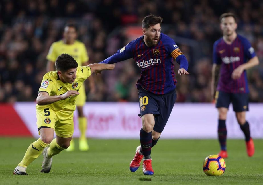 FC Barcelona's Lionel Messi (right) duels for the ball with Villarreal's Santiago Caseres during the Spanish La Liga soccer match between FC Barcelona and Villarreal at the Camp Nou stadium in Barcelona, Spain on Sunday.