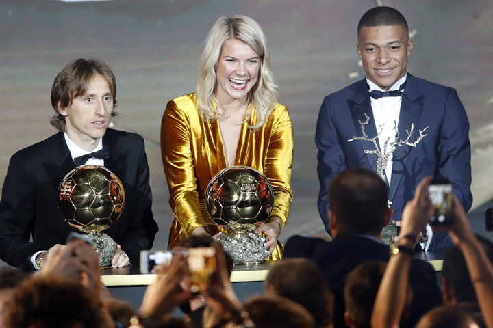 Olympique Lyonnais' Ada Hegerberg with the Women's Ballon d'Or (center) poses with Real Madrid's Luka Modric, with the Ballon d'Or (left) and Paris St Germain's Kylian Mbappe with the Kopa Trophy (right) during the Golden Ball award ceremony at the