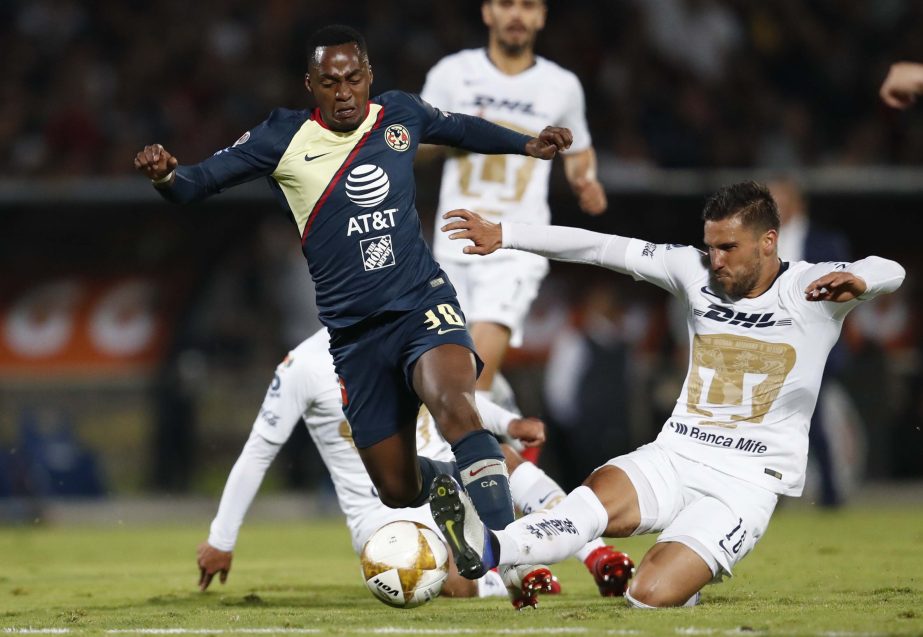 Pumas' Carlos Gutierrez (right) fights for the ball with America's Alex Ibarra during a Mexico soccer league first leg semifinals match in Mexico City on Thursday.