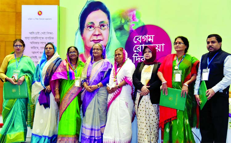 Marking the Begum Rokeya Day, Prime Minister Sheikh Hasina poses for a photo session with the Rokeya Award recipients and their family members at the Bangabandhu International Conference Centre on Sunday.