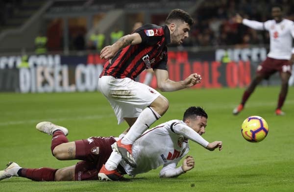 AC Milan's Patrick Cutrone, challenges for the ball with Torino's Armando Izzo during a Serie A soccer match between AC Milan and Torino , at the San Siro stadium in Milan, Italy on Sunday.