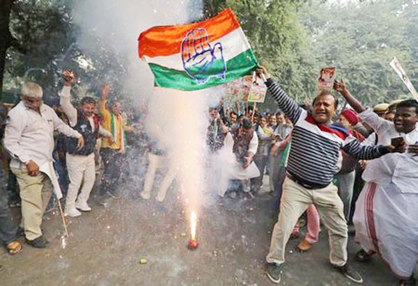 Supporter of India's main opposition Congress party waves the party's flag and celebrates after the initial poll results at the party headquarters in New Delhi on Tuesday.