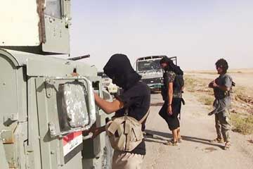 An image made available by the jihadist Twitter account Al-Baraka news on June 13, 2014 allegedly shows Islamic State militants inspecting abandoned Iraqi army vehicles.