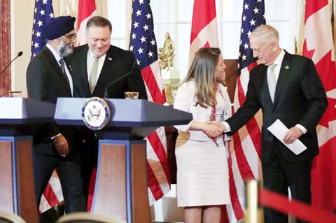 Secretary of State Mike Pompeo, (second from left), and Defense Secretary Jim Mattis (right), shake hands with their Canadian counterparts Canadian Minister of Foreign Affairs Chrystia Freeland, second from right, and Canadian Minister of Defense Harjit S