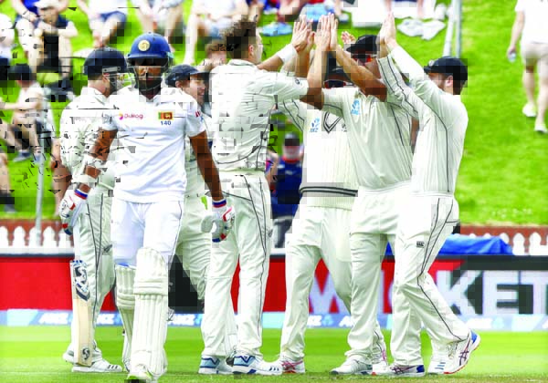 New Zealand's Tim Southee is congratulated by teammates after dismissing Sri Lanka's Danushka Gunathilaka (left) during play on day one of the first cricket Test in Wellington, New Zealand on Saturday.