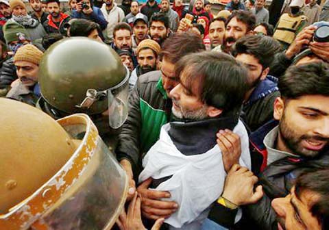 Indian police officers try to detain Mohammad Yasin Malik, Chairman of Jammu Kashmir Liberation Front (JKLF), a separatist party, during a protest march in Srinagar on Monday.