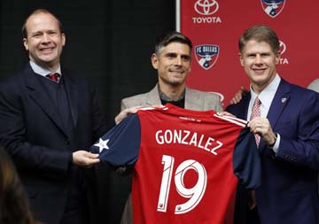 FC Dallas President Dan Hunt (left) and chairman and CEO Clark Hunt (right) present newly hired head coach Luchi Gonzalez (center) with his team jersey during a news conference in Frisco, Texas on Monday.