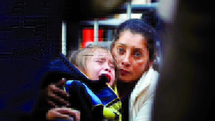 Maria Meza, a 40-year-old migrant woman from Honduras, part of a caravan of thousands from Central America trying to reach the United States, holds her daughter as she waits at the Otay Mesa port of entry in San Diego, California to be processed as an asy