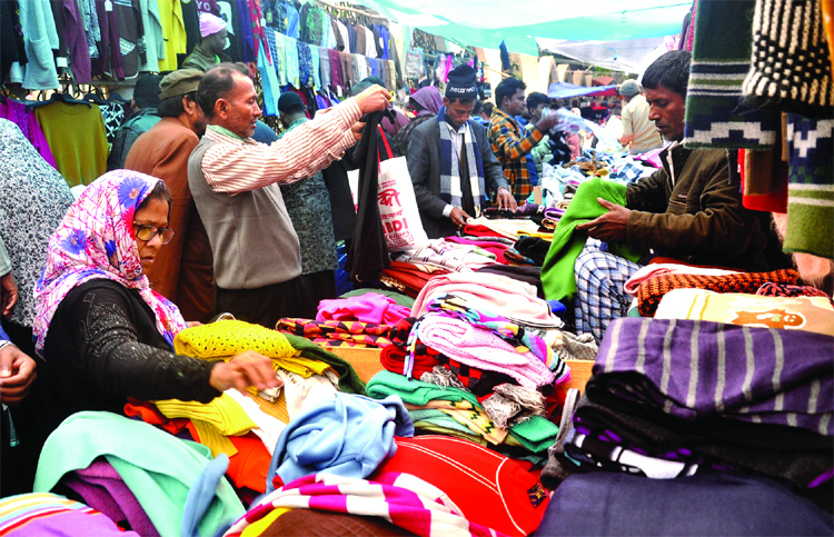 As the country is experiencing mild cold wave, people are seen making their choice to purchase warm clothes from city footpaths. This picture was taken from Baitul Mukarram area on Wednesday.