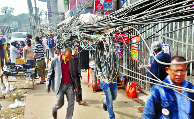Huge net and telephone cables are being spread on the footpath of Topkhana Road creating obstacles to movement of the pedestrians. But the authorities concern did not pay any heed to the matter to remove those immediately. This photo was taken from Purana