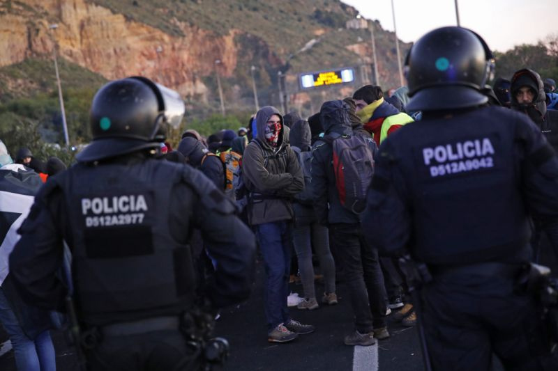 Catalan riot police prevents pro-independence demonstrators from standing on a major road near Barcelona's port area, Spain on Friday.