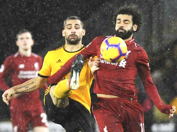 Wolverhampton's Jonny Otto (left) and Liverpool's Mohamed Salah challenge for the ball during the English Premier League soccer match between Wolverhampton Wanderers and Liverpool at the Molineux Stadium in Wolverhampton, England on Friday.