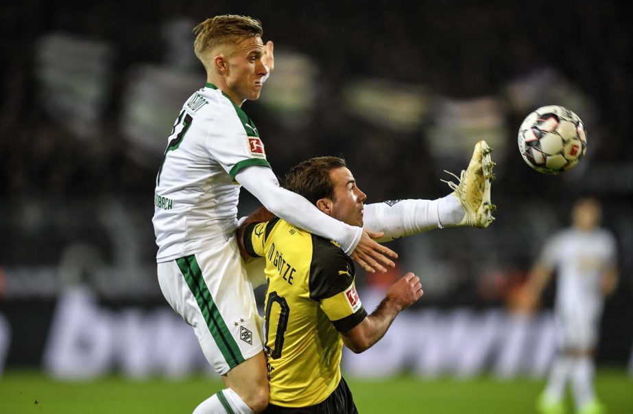 Moenchengladbach's Oscar Wendt (left) and Dortmund's Mario Goetze challenge for the ball during the German Bundesliga soccer match between Borussia Dortmund and Borussia Moenchengladbach in Dortmund, Germany on Friday.