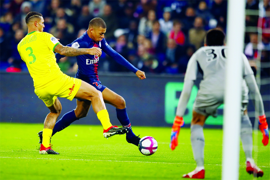 PSG forward Kylian Mbappe (center) vies with Nantes' Diego Carlos (left) during the League One soccer match between Paris Saint Germain and Nantes at the Parc des Princes stadium in Paris on Saturday.