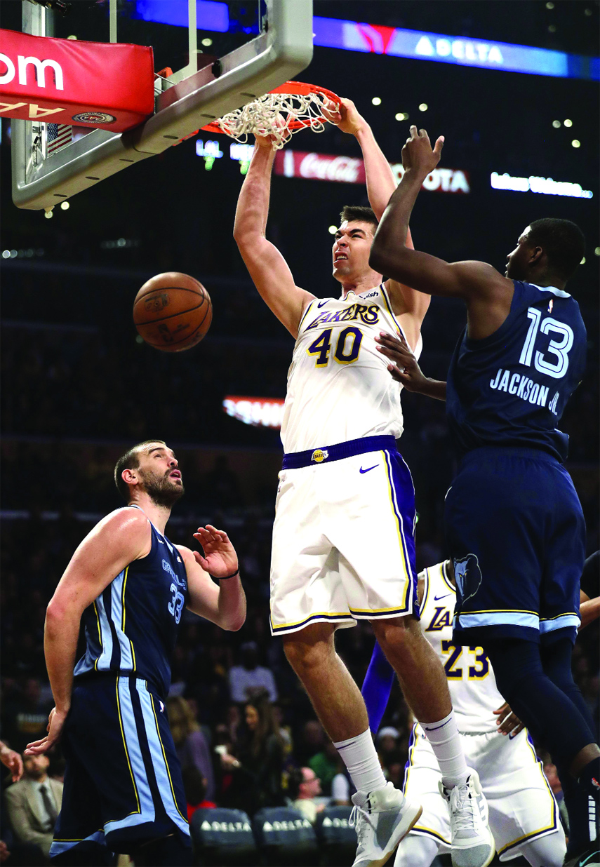 Los Angeles Lakers' Ivica Zubac (40) dunks between Memphis Grizzlies' Marc Gasol (left) and Jaren Jackson Jr. (13) during the first half of an NBA basketball game in Los Angeles on Sunday