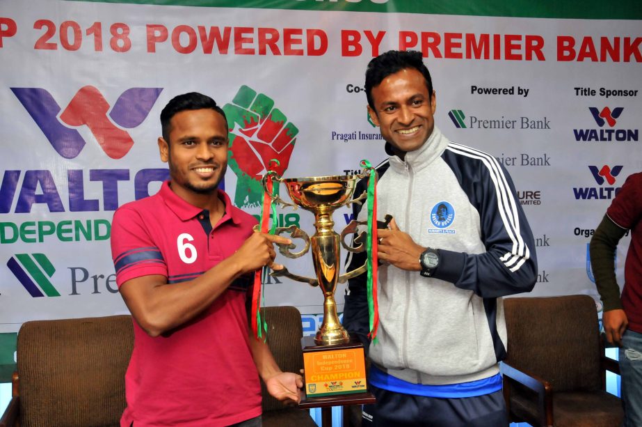 Captain of Bashundhara Kings Emon Mahmud Babu and Captain of Sheikh Russel Krira Chakra Limited Ashraful Islam Rana pose with the Walton Independence Cup at the conference room in Bangladesh Football Federation House on Tuesday.