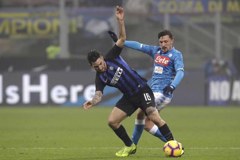 Inter Milan's Matteo Politano (left) fights for the ball with Napoli's Mario Rui during a Serie A soccer match between Inter Milan and Napoli, at the San Siro stadium in Milan, Italy on Wednesday.