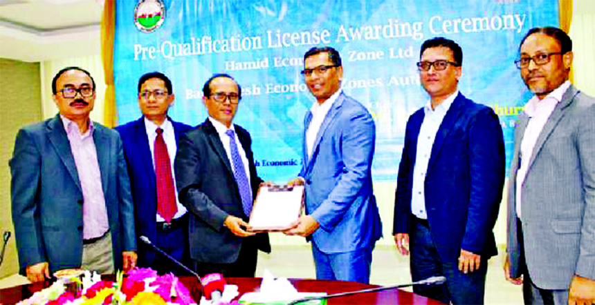 Paban Chowdhury, Executive Chairman of Bangladesh Economic Zone Authority (BEZA), handing over the pre-qualified licence to the officers of Hamid Economic Zone at BEZA office on Wednesday.
