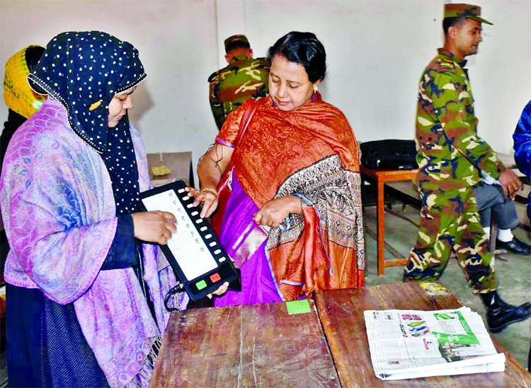 Election Commission staff showing how to use EVMs voting in national election on Dec 30. This photo was taken from Sher-e-Bangla Girls' School in city's Wari on Thursday.