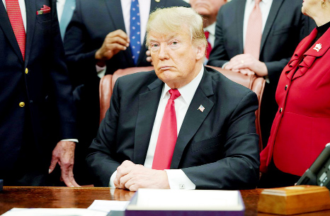 President Donald Trump listens to questions from reporters in the Oval Office of the White House on Tuesday.