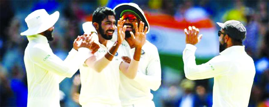 Jasprit Bumrah (2nd from left) celebrates with his teammates after dismissal of an Australian wicket during the third day play of the third Test between India and Australia at Melbourne in Australia on Friday.